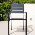 Modern black patio chair with plastic wood slats and armrests