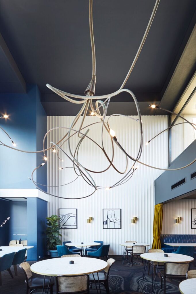 Modern restaurant interior with round tables and blue seating