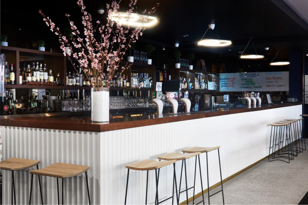 Modern bar interior with a long white counter