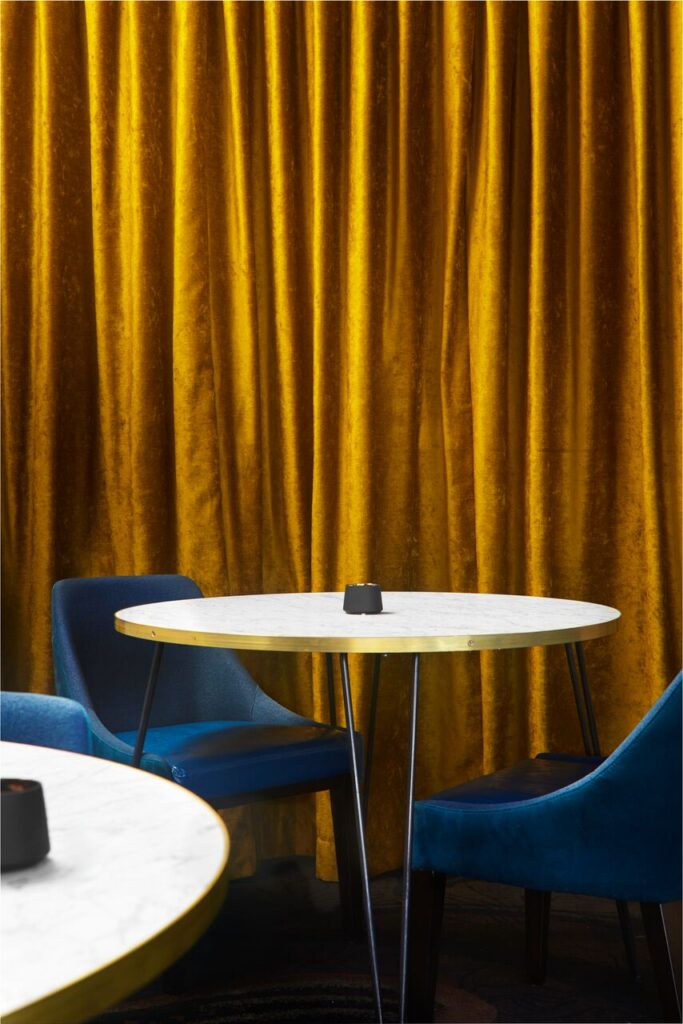 Small round cafe table with blue upholstered chairs set