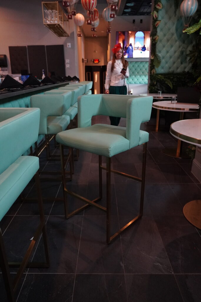 Row of turquoise upholstered bar stools lined along