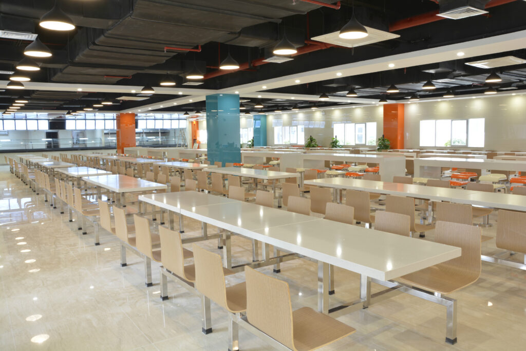 Large modern cafeteria with long tables, chairs